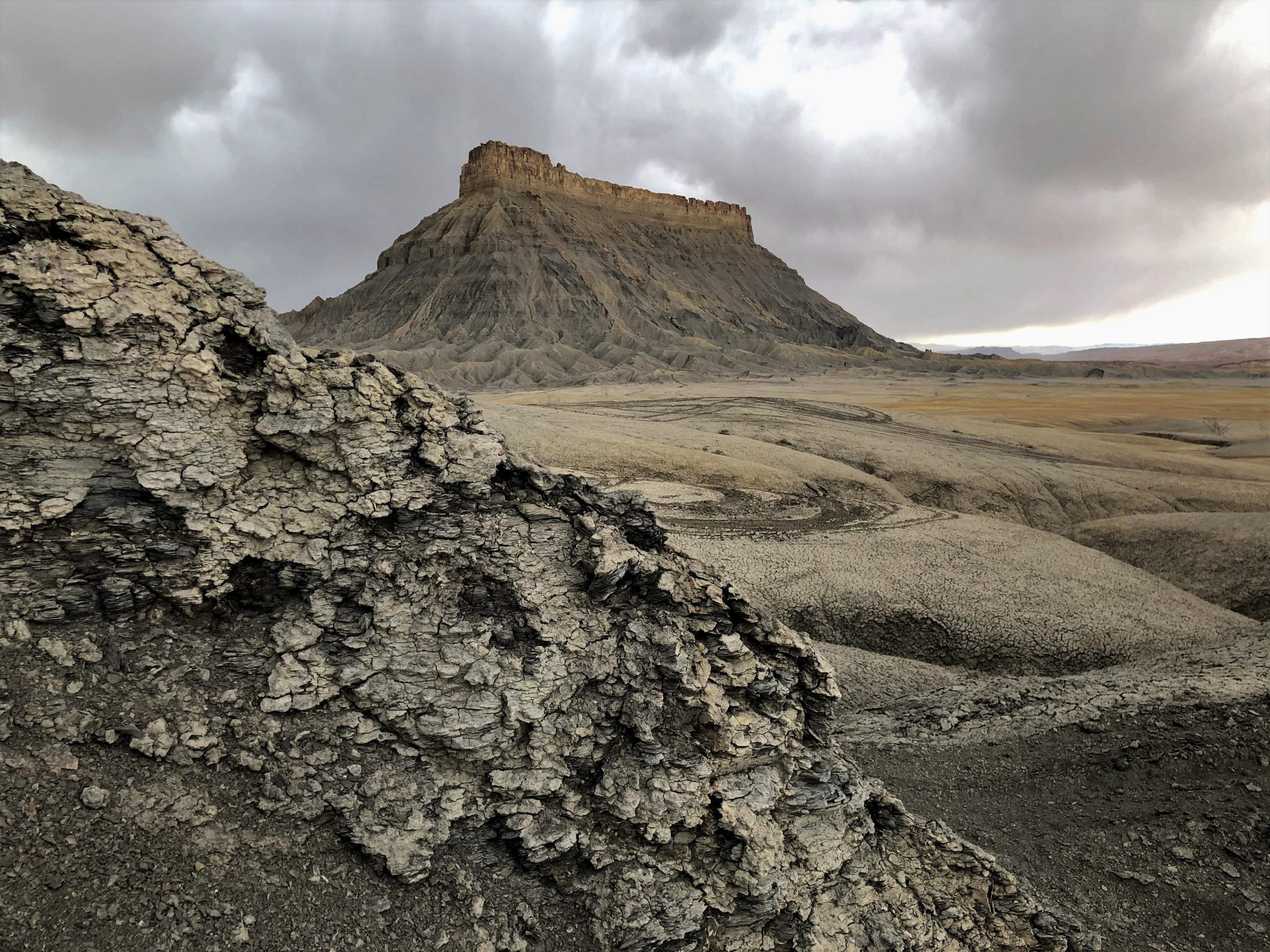 a shot of factory butte in utah with cloudy skies
